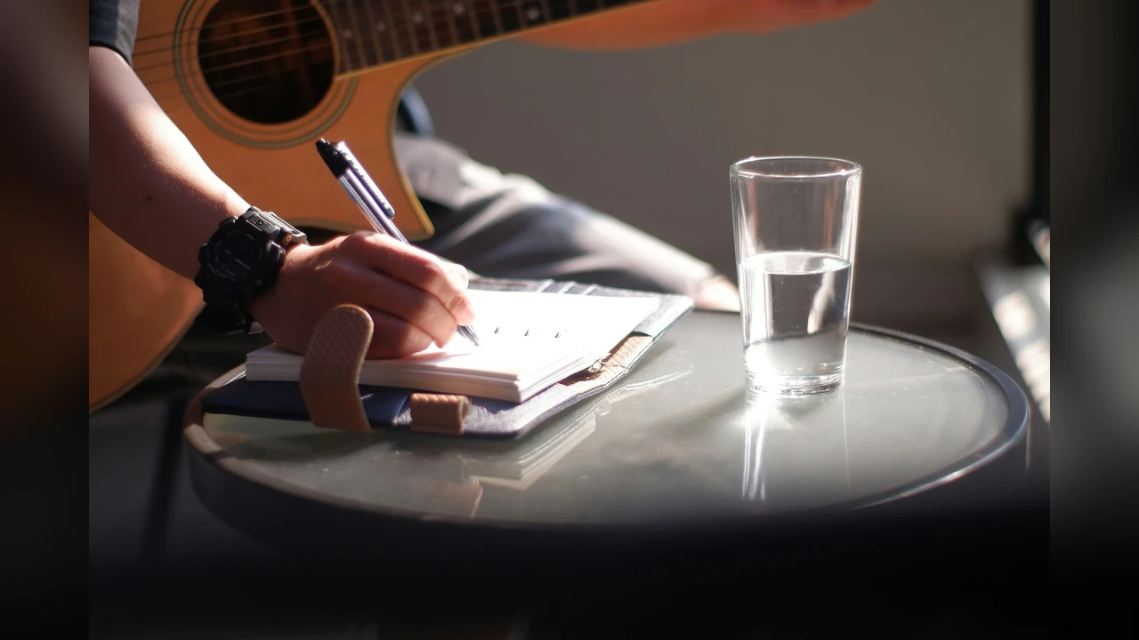 AIRapGenerator: writing a verse in a notebook next to a guitar